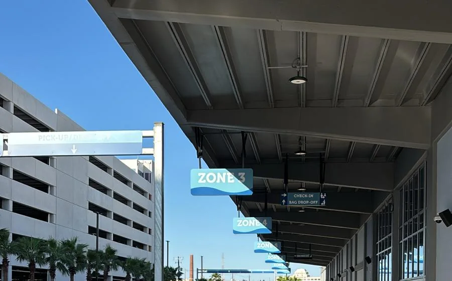Numbered pickup and drop-off zone signs along the curb at Galveston Cruise Terminal 16